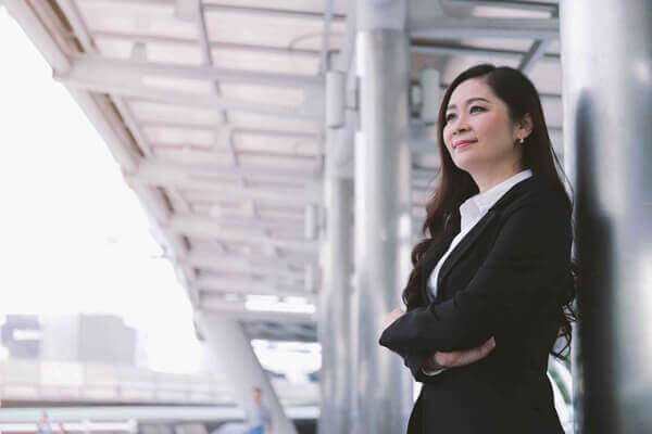 Successful asian senior businesswoman leader standing over modern office background