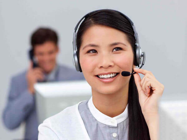 Young asian businesswoman with headset on at her desk in the office