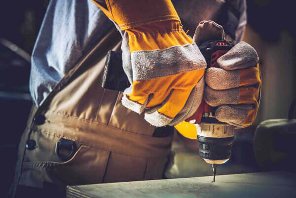 Men Fixing Wooden Shelf with His Driller.